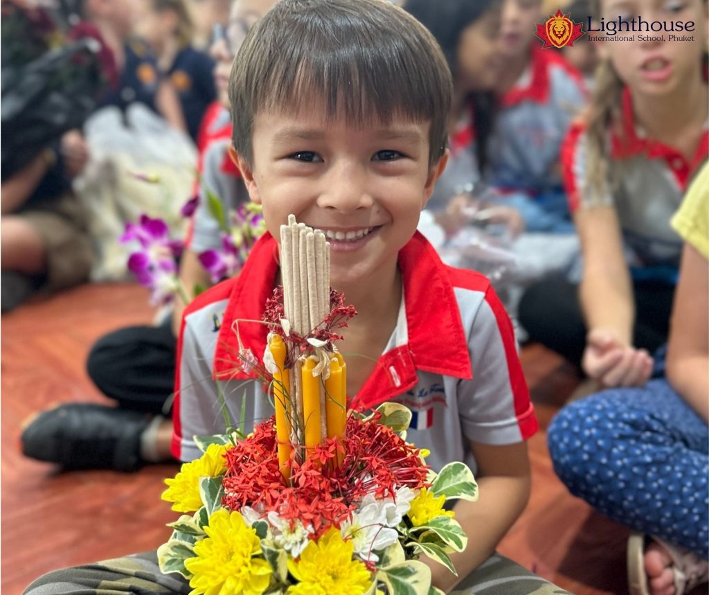 Little boy holding a flower arrangement while smiling at the camera