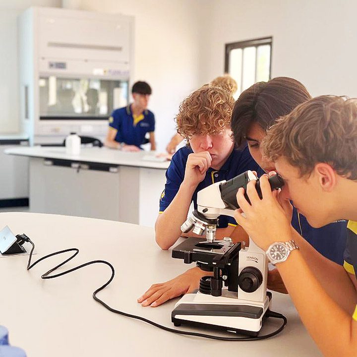 new science lab with high school class using microscope