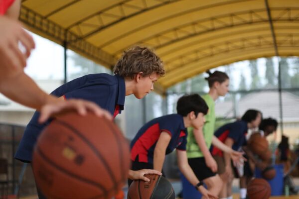 A line up of boys dribbling basketball