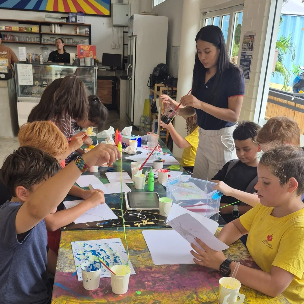 Children doing arts crafts with teacher's supervision