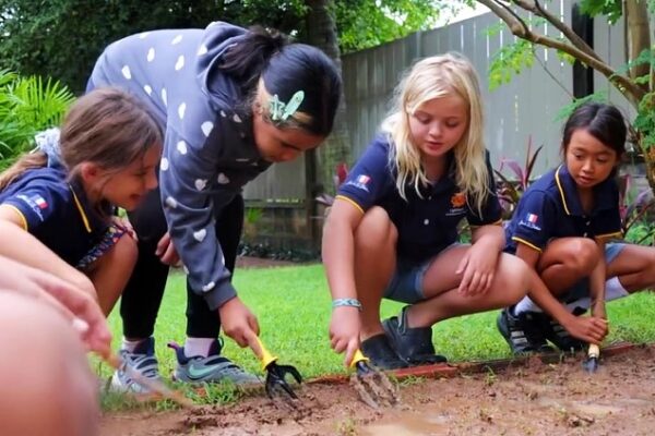 Girls planting with teacher