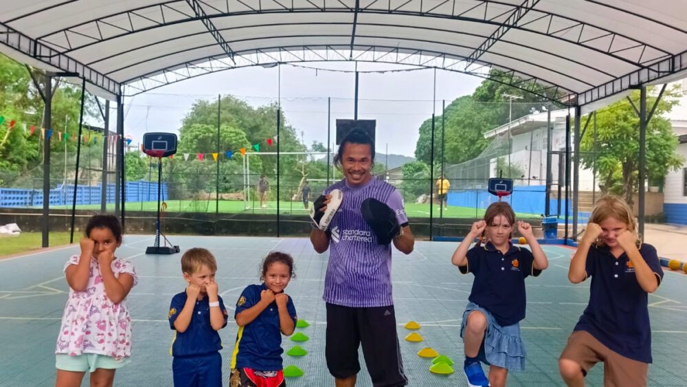 Primary students posing with coach