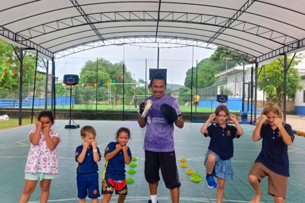 Primary students posing with coach