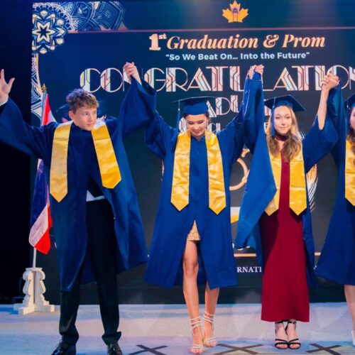 Image of secondary students holding their hands up for graduation
