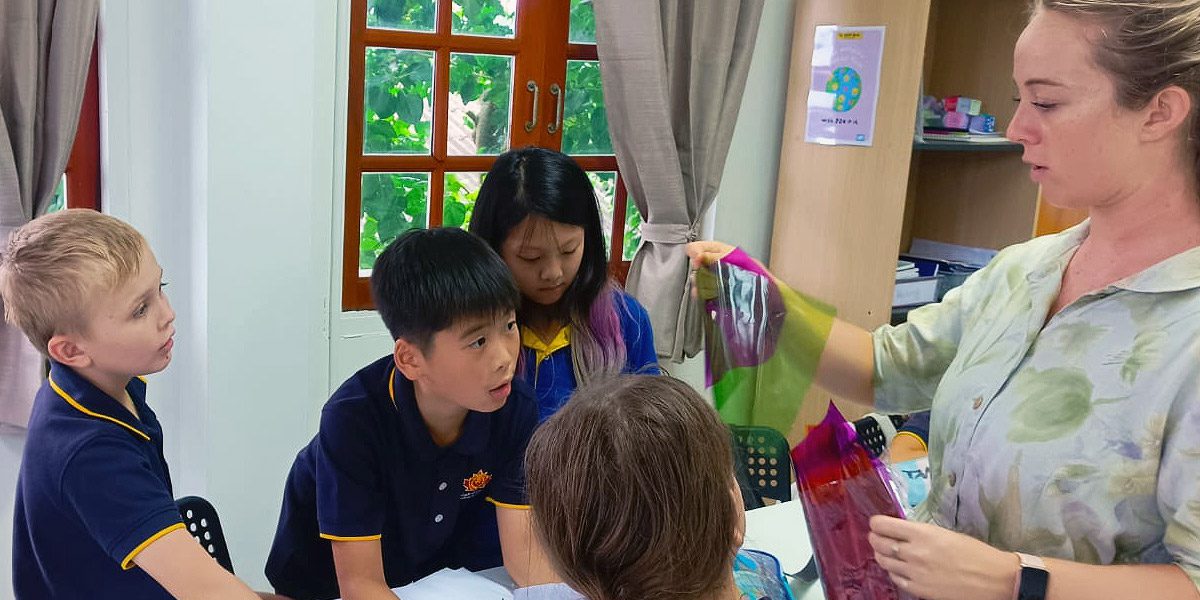 highlights-lighthouse-primary-school-small-class-sizes A photo of a teacher showing different color combinations from cellophanes to primary students