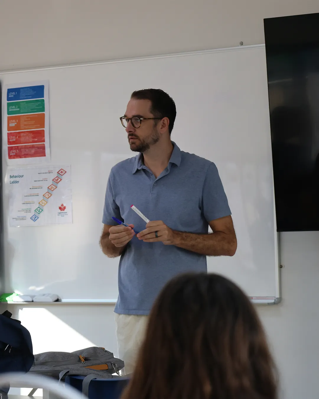 Teacher holding a marker as he discusses Teacher holding a marker as he discusses