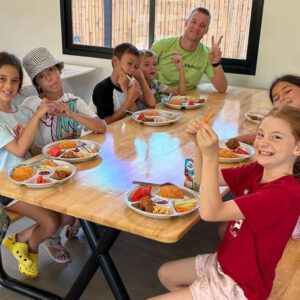 kids-holiday-camp-canteen-healthy-food Kids posing for a picture as they eat in the canteen