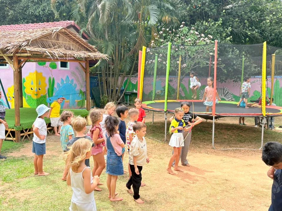 Children outdoors with a trampoline