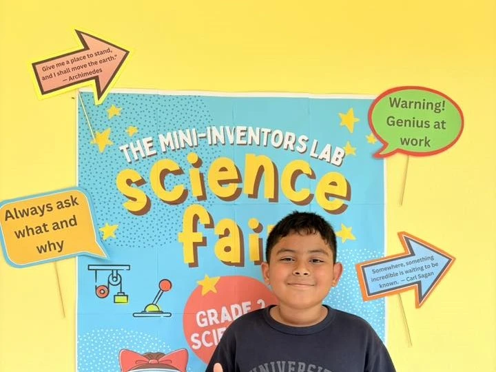 Kid posing in front of a poster