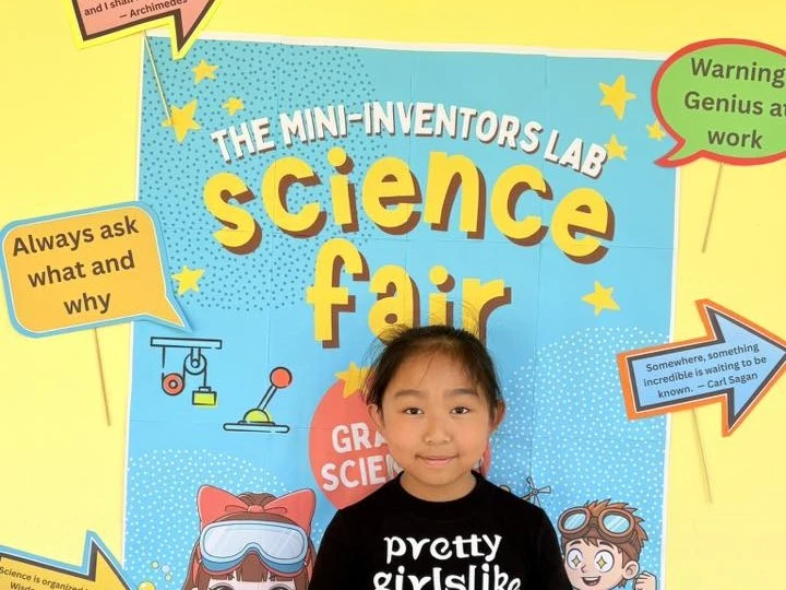 Little girl posing in front of the poster