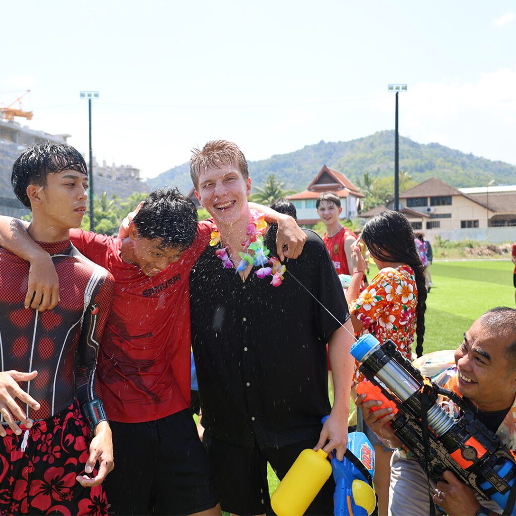 A teacher playing watergun with students