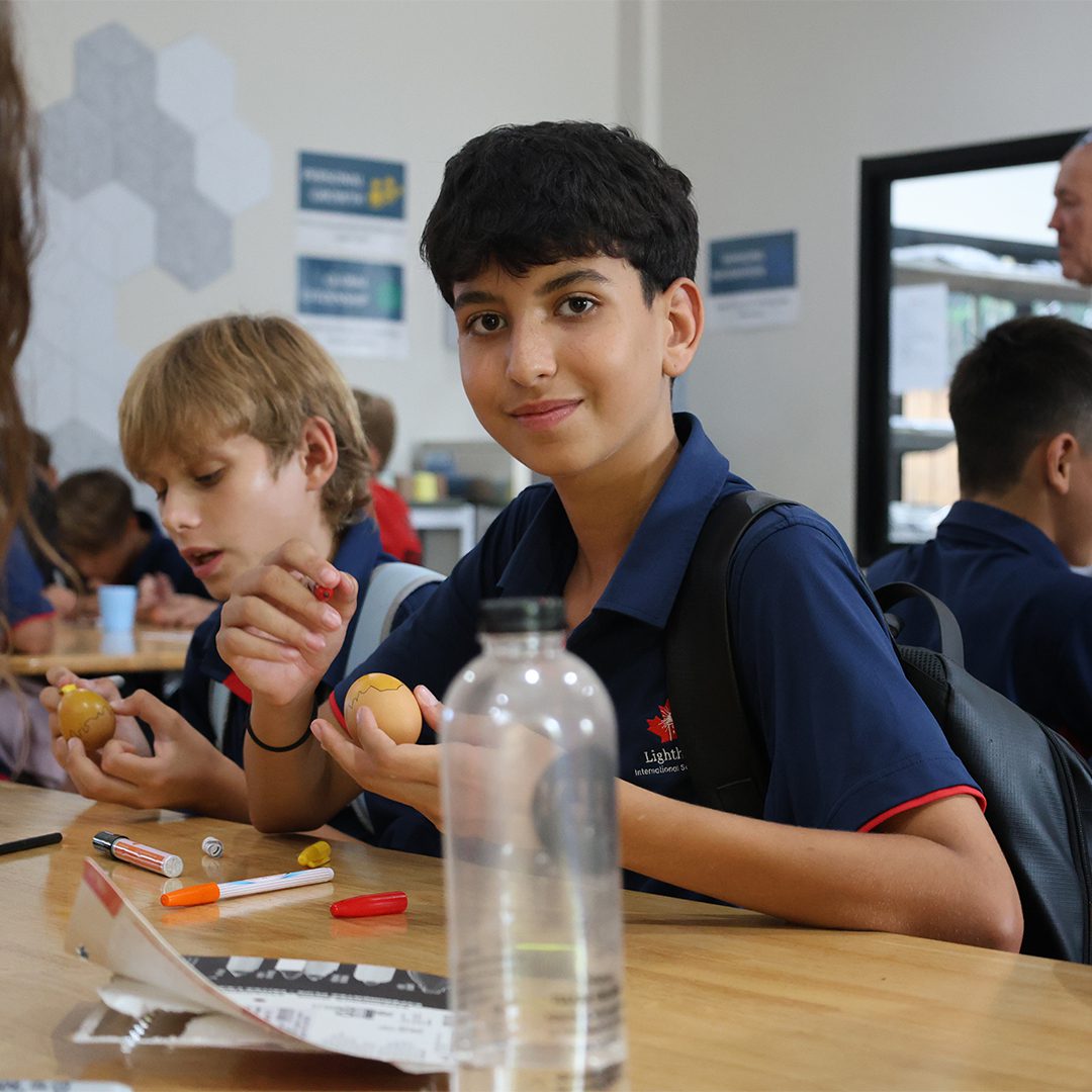 Boy smiling as he paints an egg