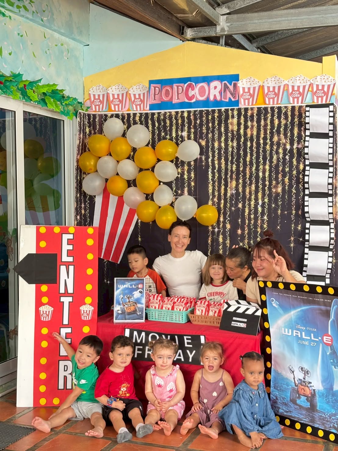 Children sitting by a popcorn booth