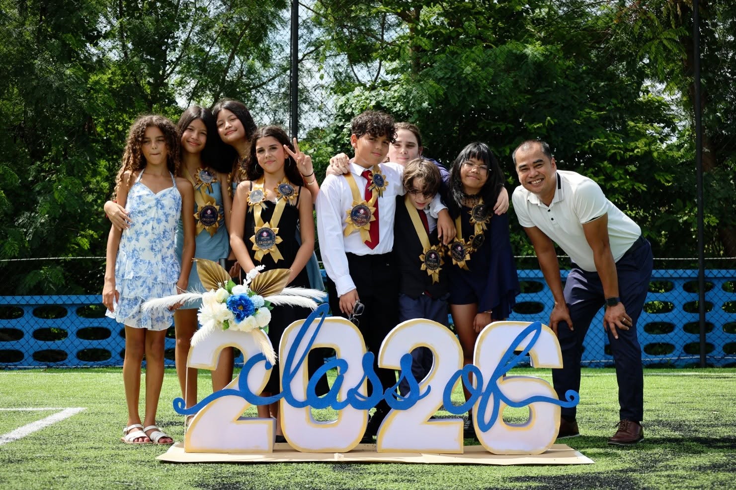 Class of 2026 Grade 6 graduates with their teacher