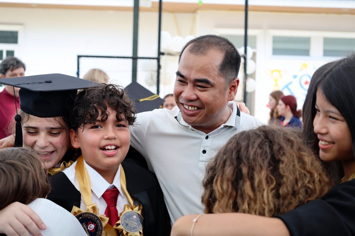 Grade 6 graduates hugging their teachers