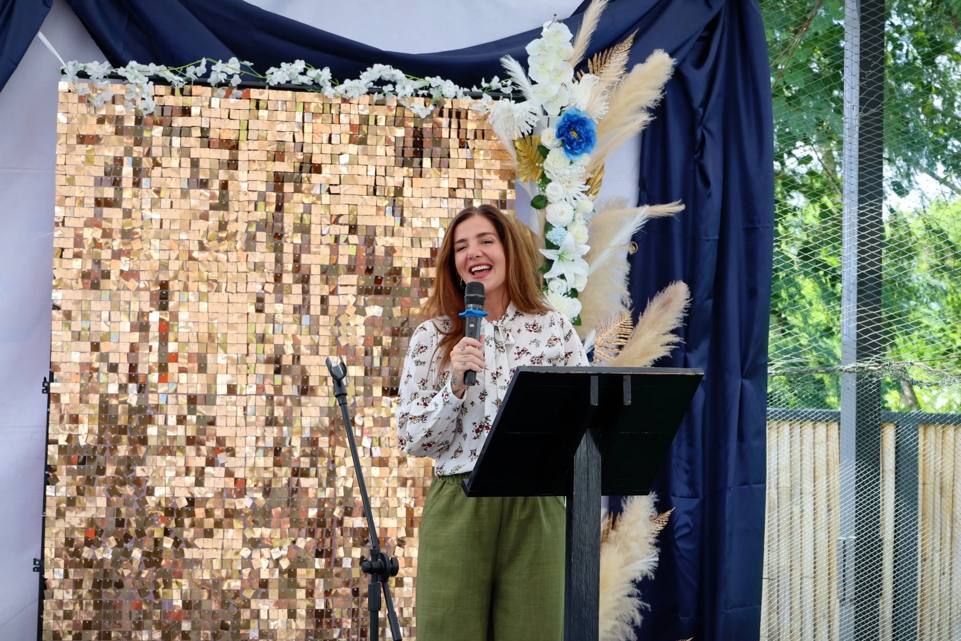 Head or teacher beaming as she gives a speech for the 6th grade graduates