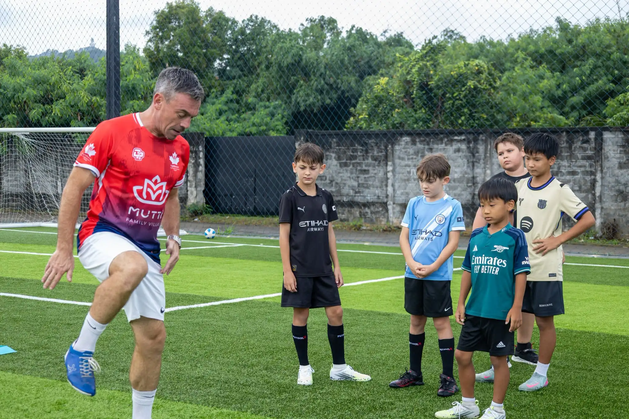 Football coach teaching students for Football summer camp