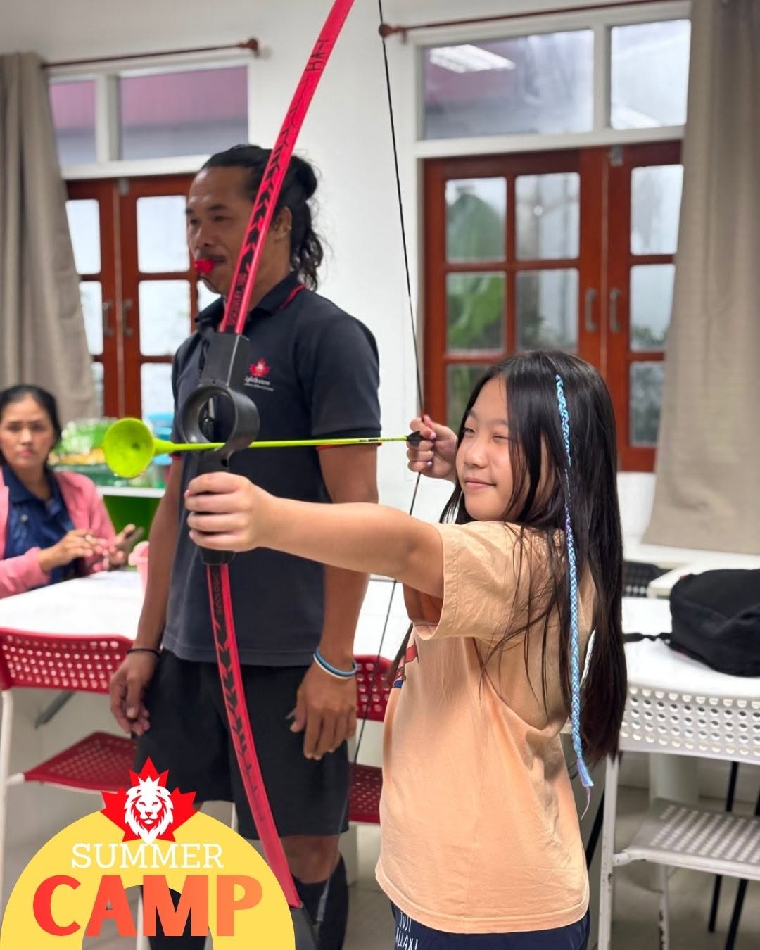 Girl using bow and arrow toy at Primary Summer Camp at Lighthouse International School