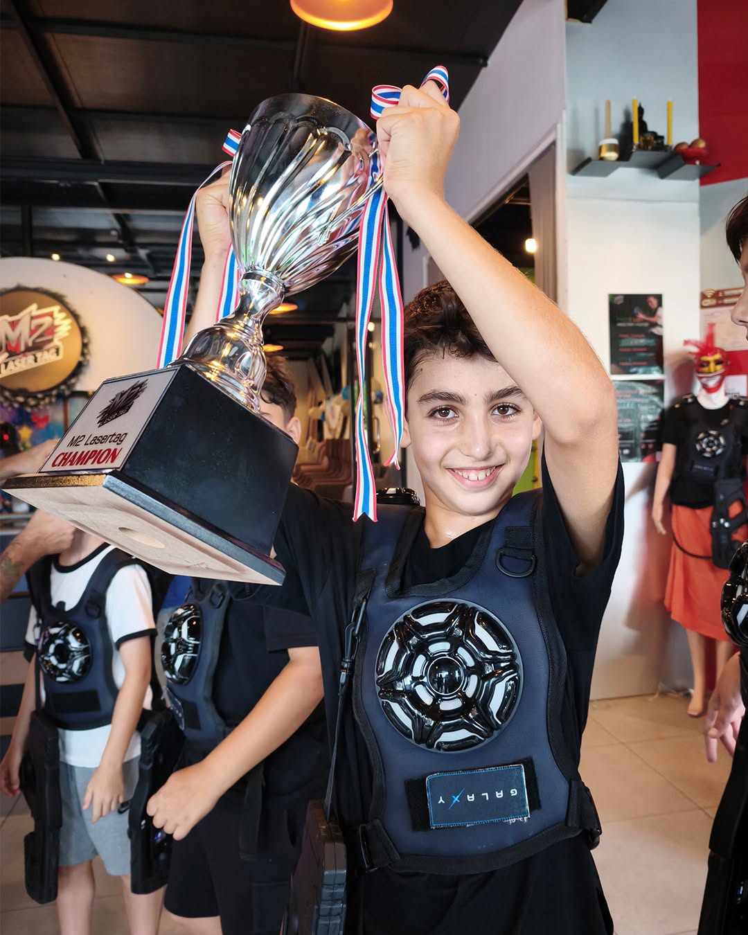 Boy smiling with trophy for winning laser tag - Lighthouse