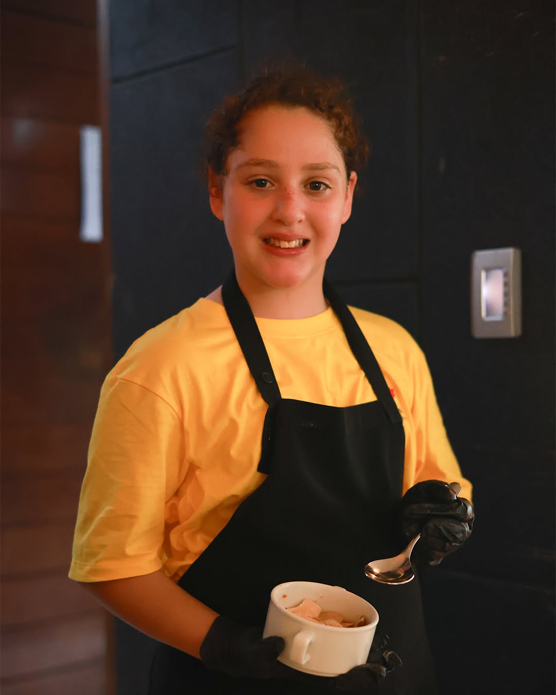 Student smiling while holding kitchenware Student smiling while holding kitchenware