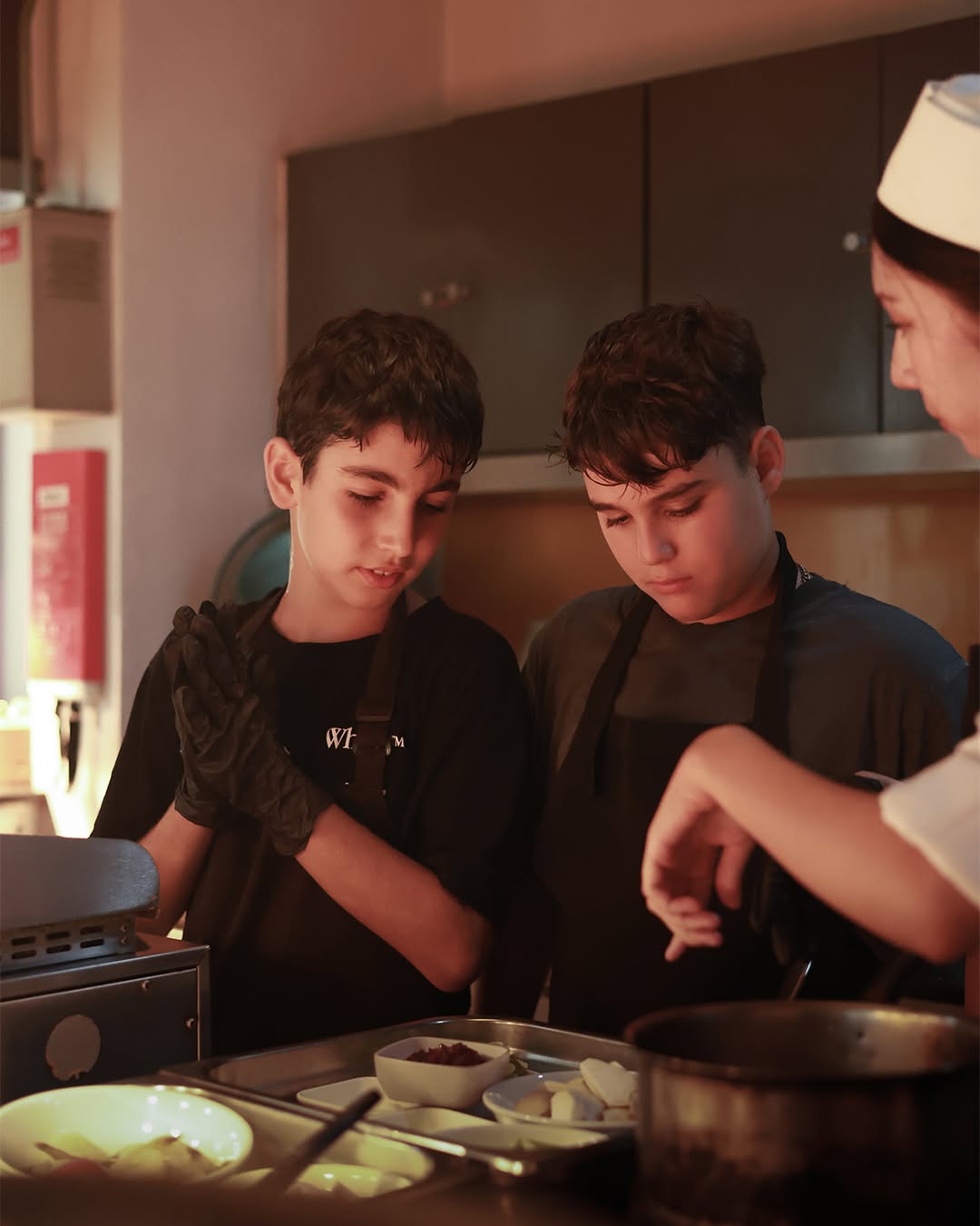 Two boys listening to the professional chef - Lighthouse Masterchef Two boys listening to the professional chef - Lighthouse Masterchef