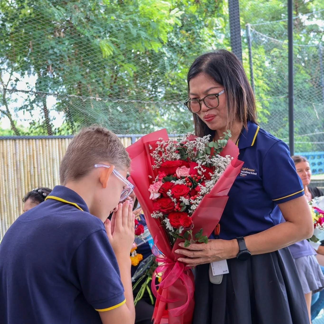 A Lighthouse International School student offering flowers and respect to his teacher for Wai Kru Day