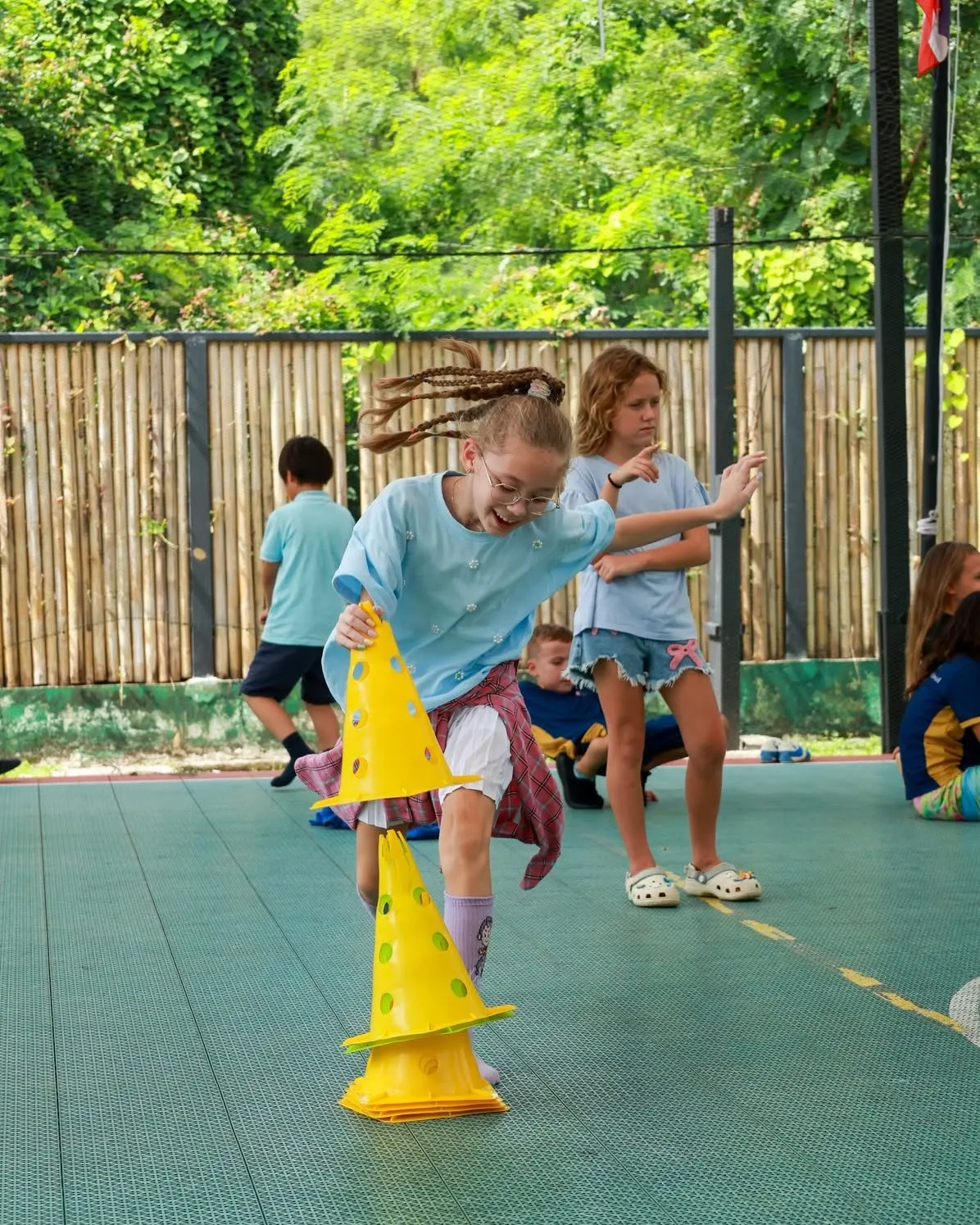 Girl running happily as she stacks cones - Lighthouse International School Phuket Girl running happily as she stacks cones - Lighthouse International School Phuket