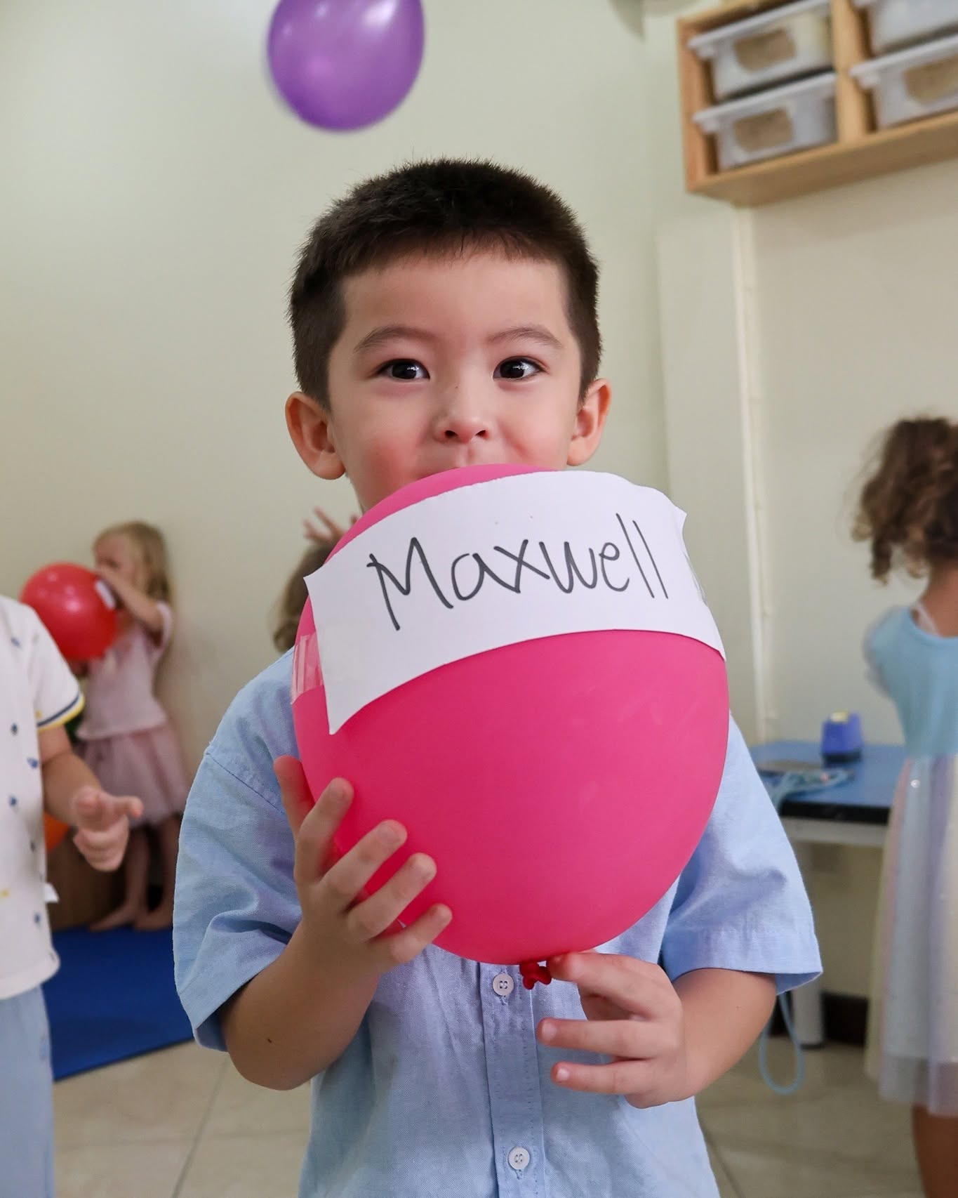 Young boy holding a balloon with his name - Lighthouse International School Young boy holding a balloon with his name - Lighthouse International School