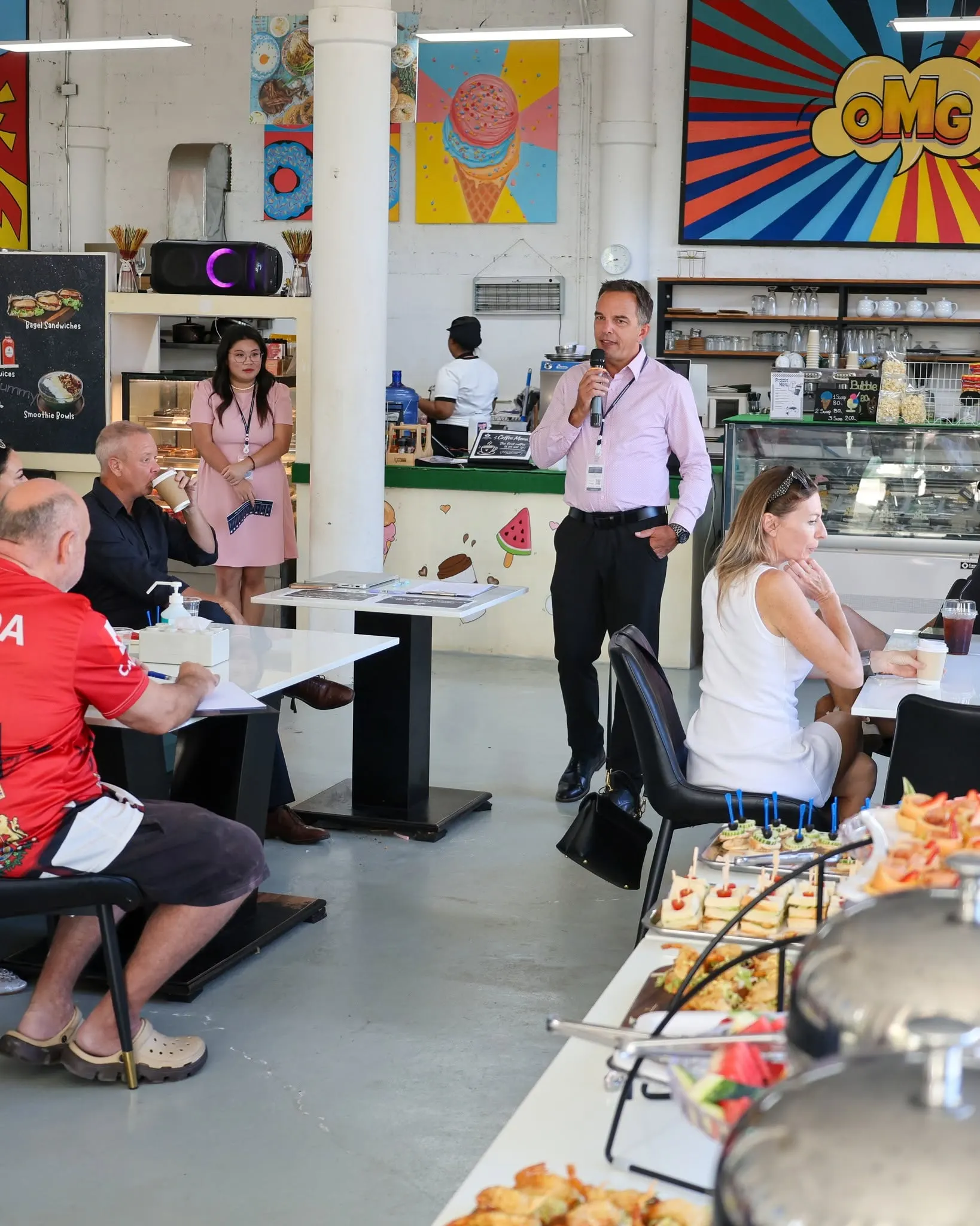 School leader speaking into a microphone to parents at Lighthouse International School Coffee Time.